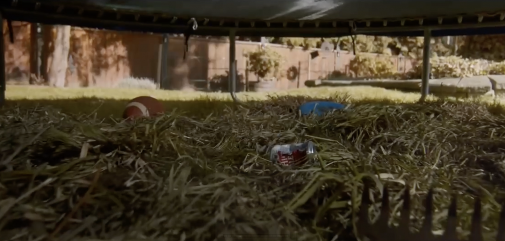 Мятая банка пива Hice Pale Ale лежит под батутом